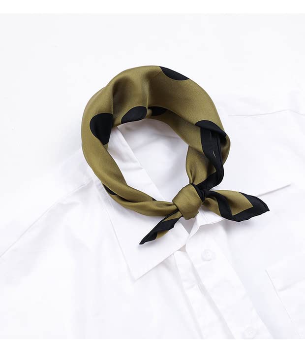 Olive polka dot silk square knotted around the collar of a white shirt, laid flat