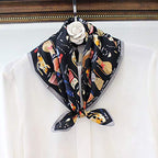 Cat print square tied at the collar of a white blouse on a hanger with a fabric flower