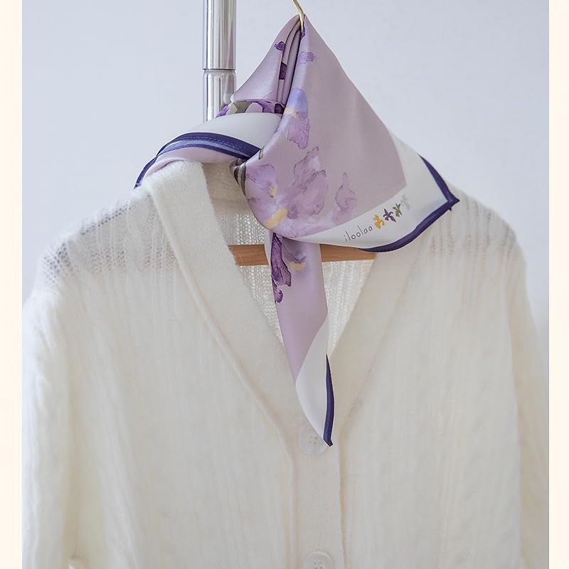 Iris square knotted at the collar of a white cable-knit cardigan on a wooden hanger