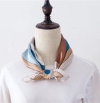 Blue and brown cat print square knotted at the neck of a dress form over a white tee