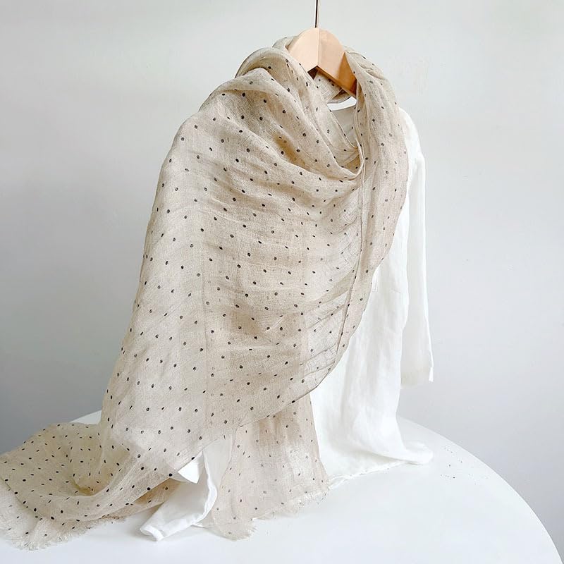 Polka dot linen scarf draped, the beige flax ground reading through between the printed dots