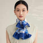 Blue and white daylily silk scarf tied in a full bow at the neck showing the deep cobalt border