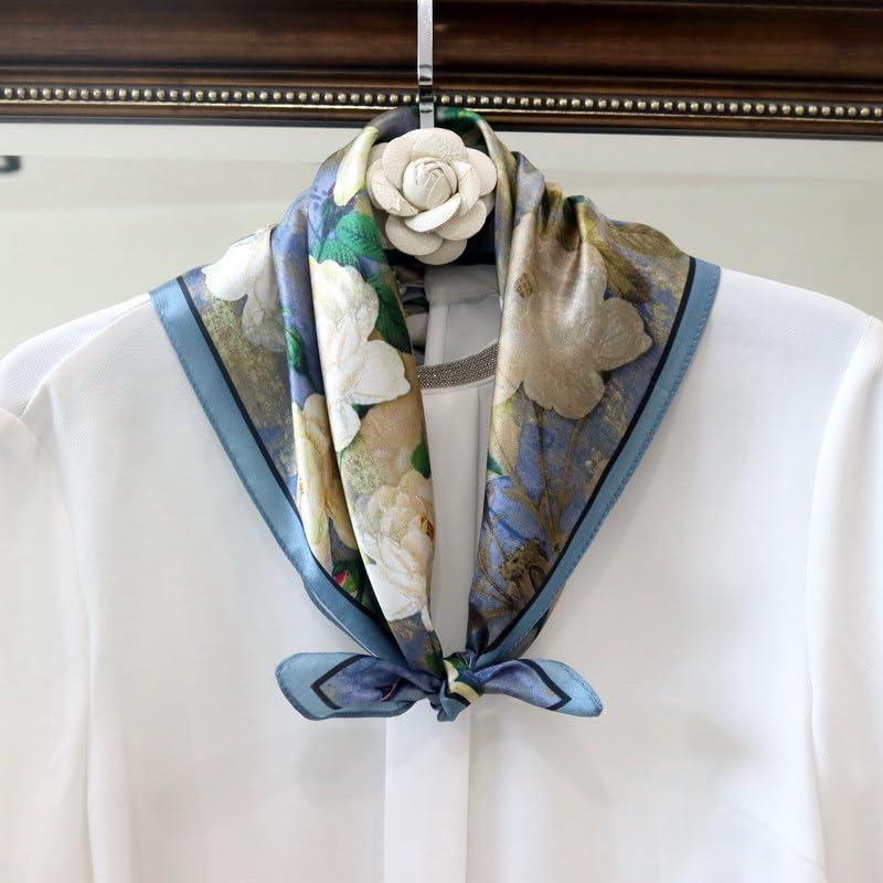 Blue camellia square tied at the collar of a white blouse on a hanger, flower pin above