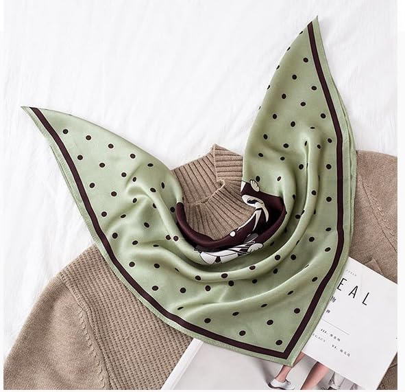 Sage green dotted square spread over a camel sweater, cat medallion gathered at the centre