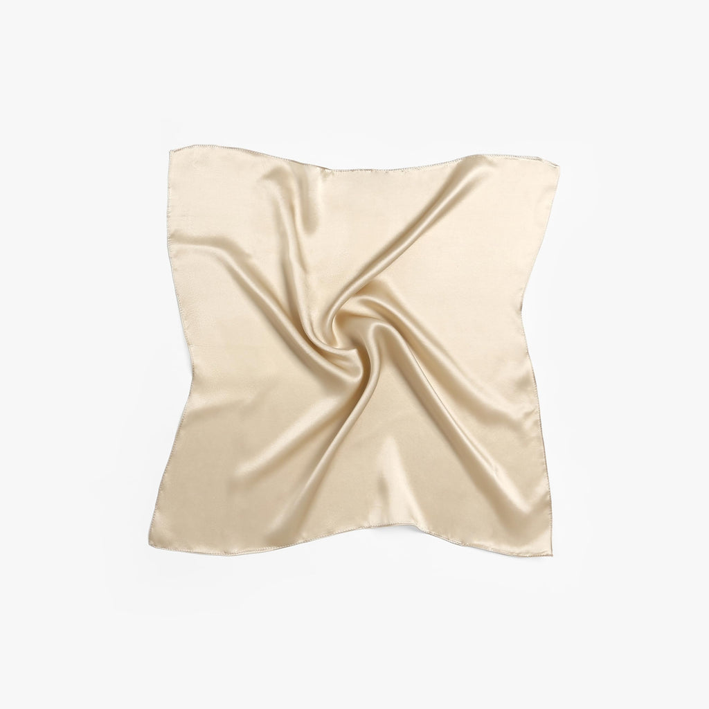 Champagne beige silk square laid flat with a pinwheel swirl gathered at the centre
