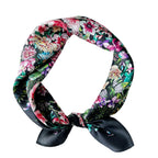 Black floral square coiled into a neck loop and tied, pink blooms massed all over