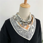 Cream animal square knotted at a dress form's neck over a black knit