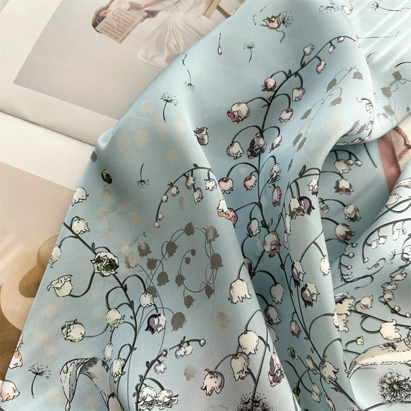 Soft folds of misty blue silk printed with dandelion clocks and lily-of-the-valley stems