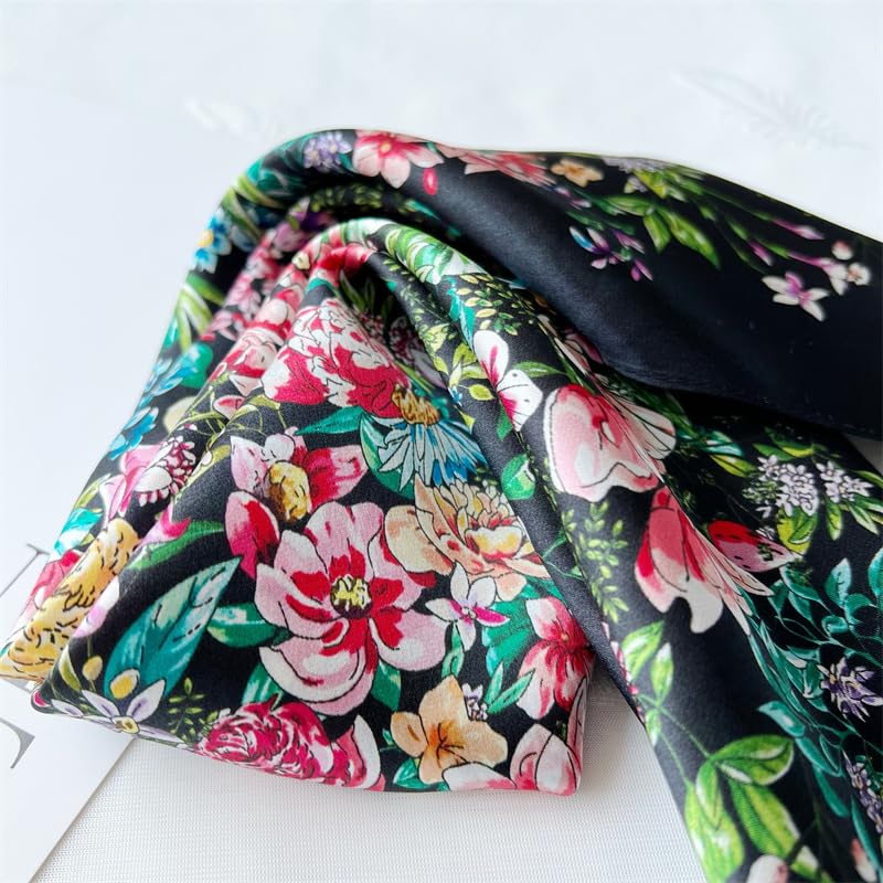Close-up of pink and cream blooms with emerald leaves on glossy black silk