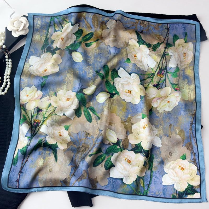 Camellia square opened flat, cream blooms and green leaves over a washed blue ground