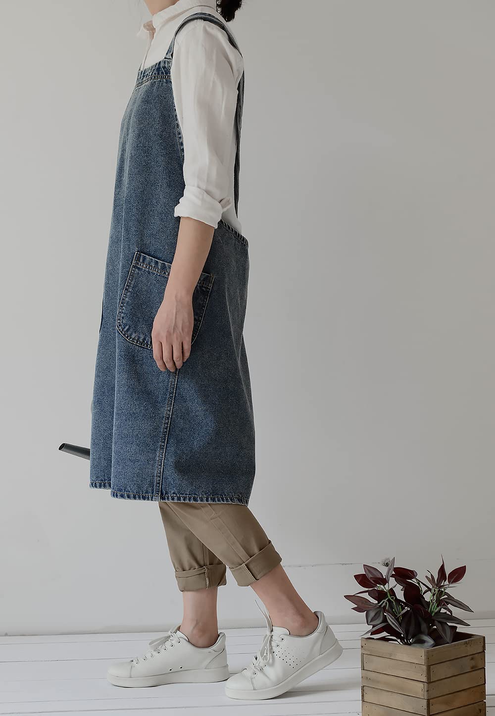 Side view of the denim pinafore apron showing how far it wraps around the body
