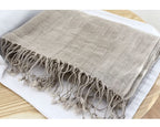 Openwork linen scarf open across the shoulders as a wide wrap