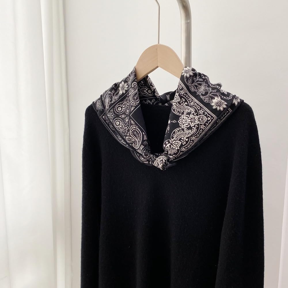 Black paisley square folded over the neckline of a black knit sweater on a hanger