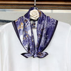 Blue toile square knotted over a white blouse on a hanger, camellia pin above