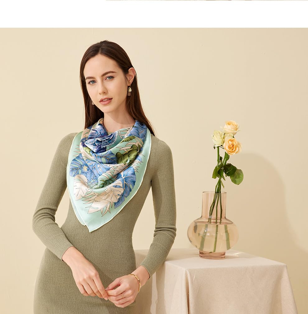 The hibiscus print silk scarf worn over an olive dress beside yellow roses