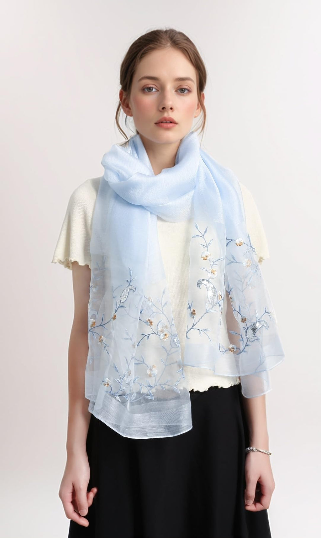 Model wearing the pale blue shawl looped once at the neck