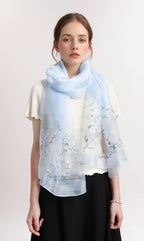 Model wearing the pale blue shawl looped once at the neck