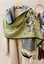 The shawl on a wooden hanger over a cream coat showing the grey lining turned back at the collar