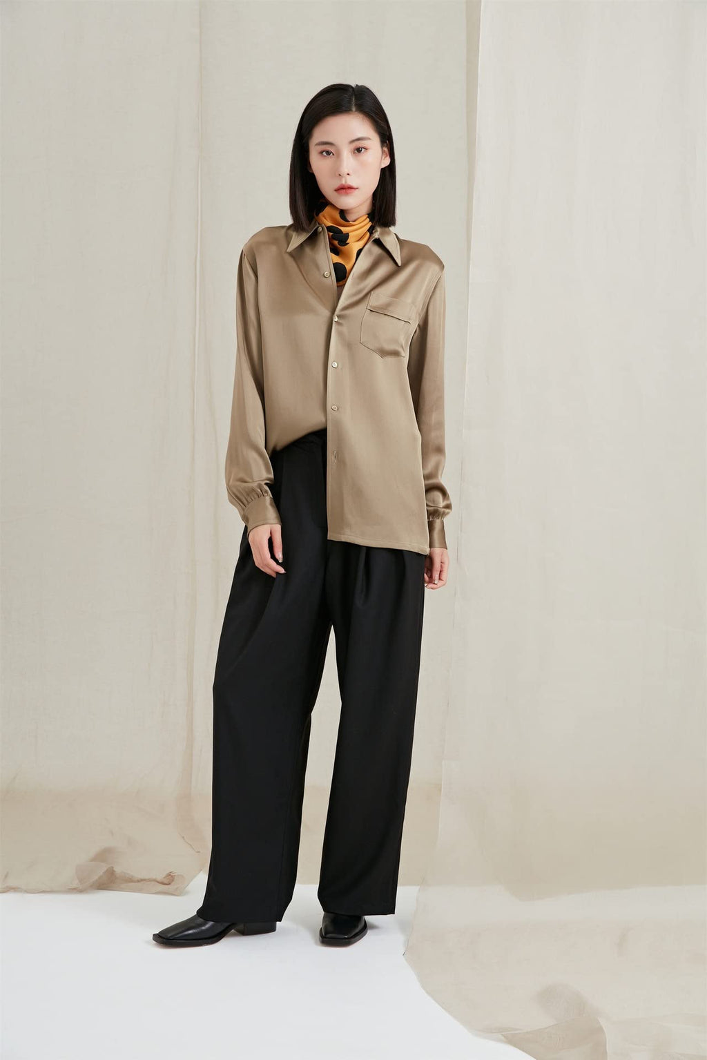 Full length look: golden dotted neck scarf, khaki satin shirt and black wide leg trousers