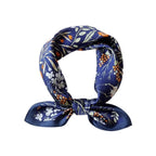 Navy garden-print square coiled into a loop and knotted, orange blooms scattered over