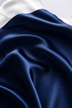 Navy silk charmeuse falling in deep folds against a cream backdrop