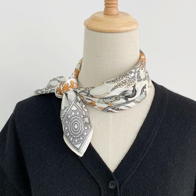Menagerie square tied at the neck of a dress form over a navy cardigan