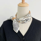 Menagerie square tied at the neck of a dress form over a navy cardigan