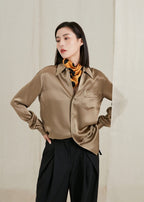 Model with hands on hips, golden dotted silk twisted into a slim band at the neck