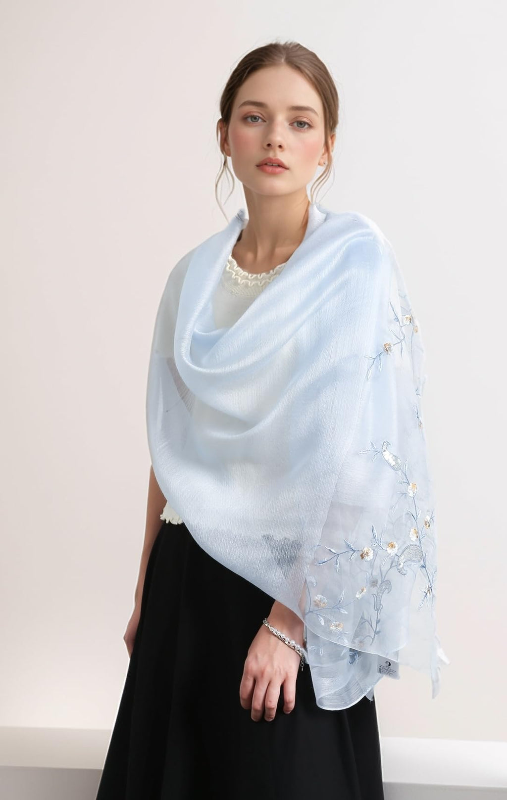Model wearing the pale blue vine embroidered shawl draped over the shoulders