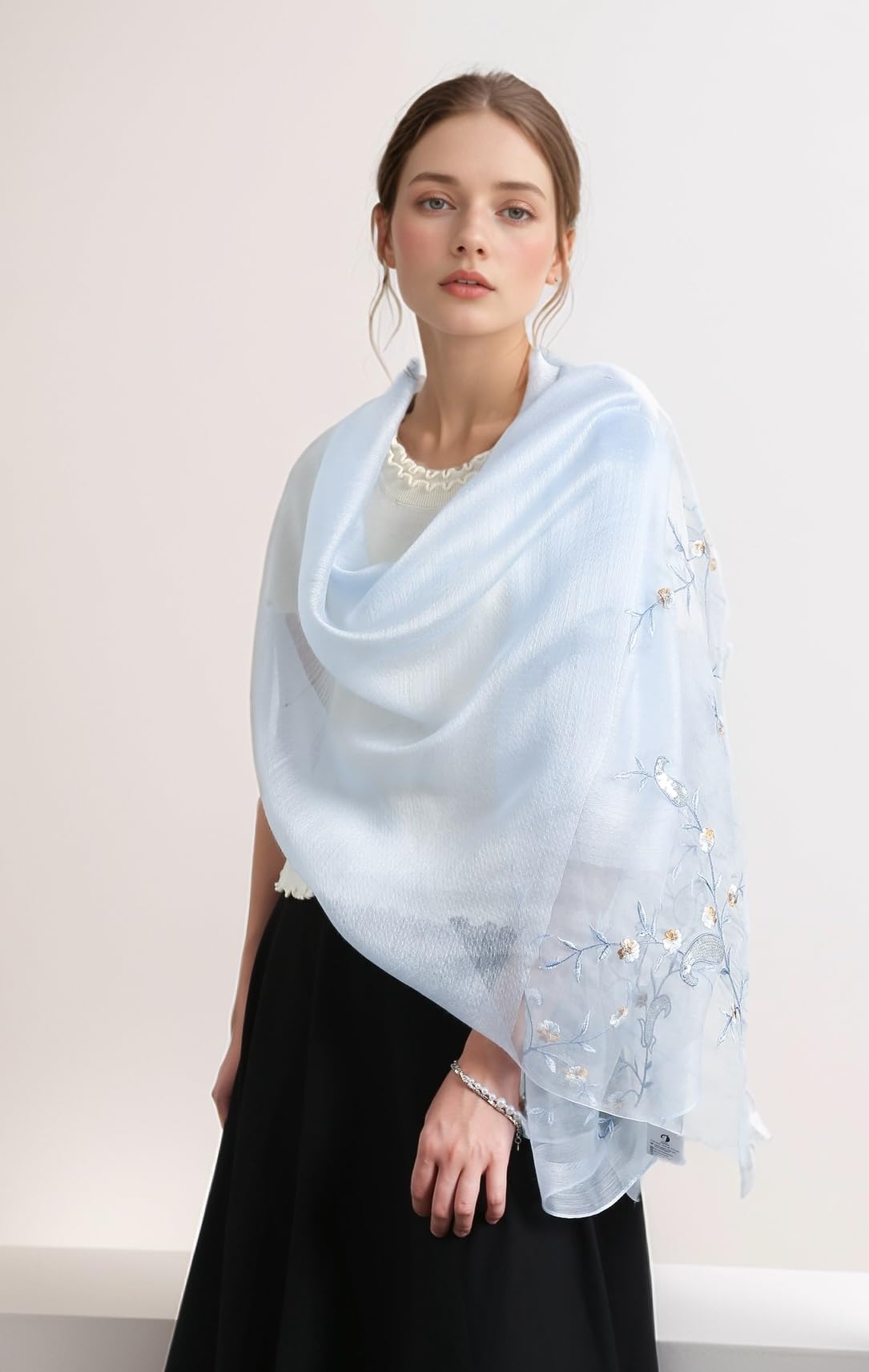 Model wearing the pale blue vine embroidered shawl draped over the shoulders