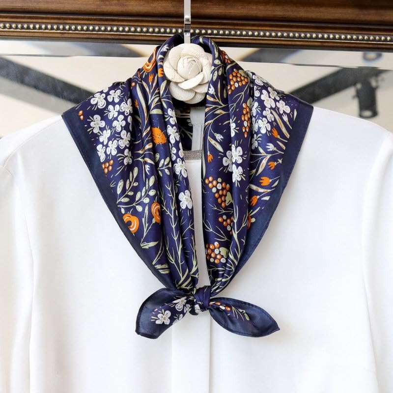Navy floral square tied at the throat over a white blouse, camellia pin at the hanger