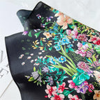 Folded black square showing the plain black corner beside the flower bouquet
