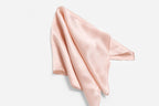 Blush pink silk square loosely draped with one hemmed corner lifted up