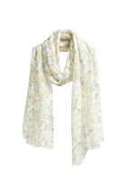 Pure linen scarf printed in warm yellow with small green leaves, frayed edge
