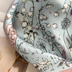 Close-up of the rose border curving over folds of misty blue silk with white bellflowers