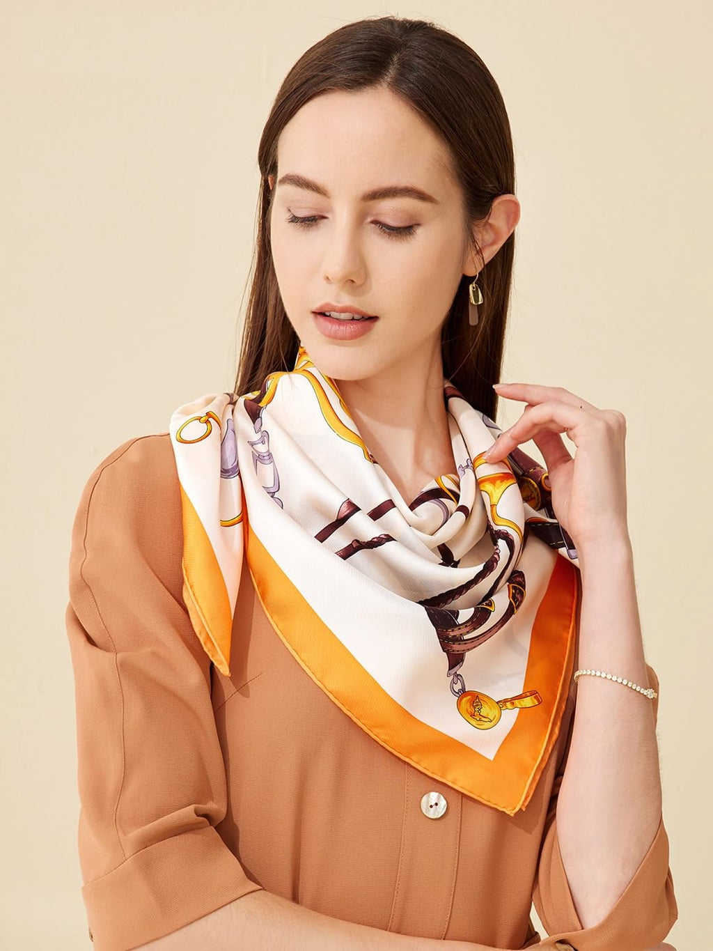 Model in a rust blouse with the cream and orange bridle print silk scarf knotted at the throat