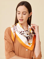 Model in a rust blouse with the cream and orange bridle print silk scarf knotted at the throat