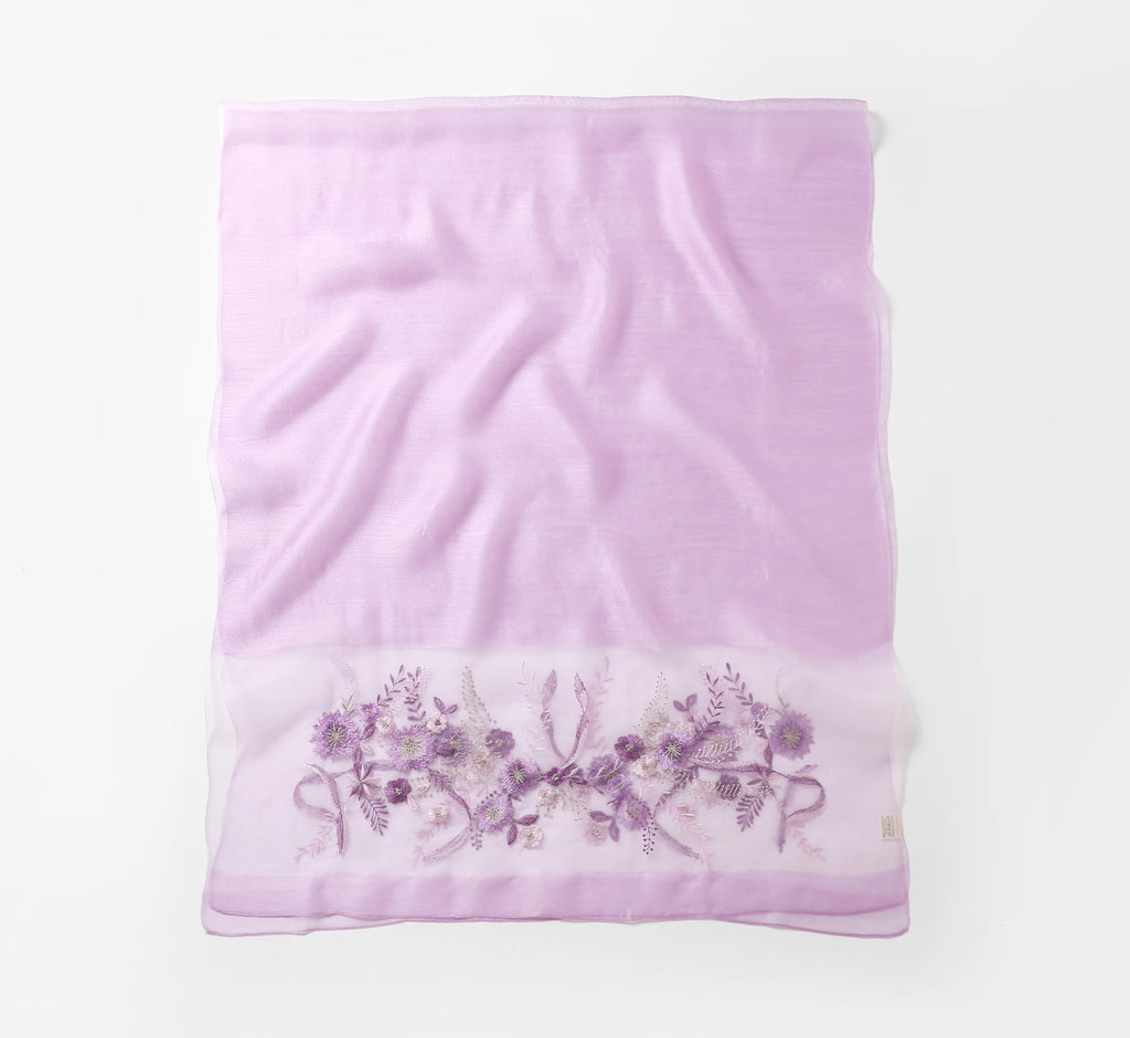 Lavender shawl folded flat showing full width with the embroidered band along the bottom edge