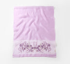 Lavender shawl folded flat showing full width with the embroidered band along the bottom edge