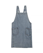 Pale washed denim apron laid flat showing two patch pockets and the split hem