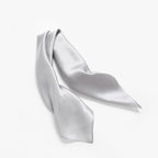 Cloud grey silk square twisted into a long band, pointed ends showing the rolled hem