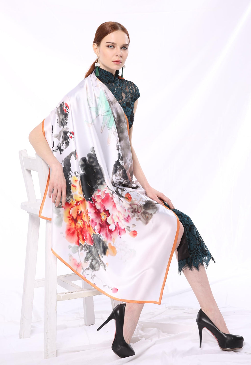 Model seated with the white ink print silk scarf over one shoulder
