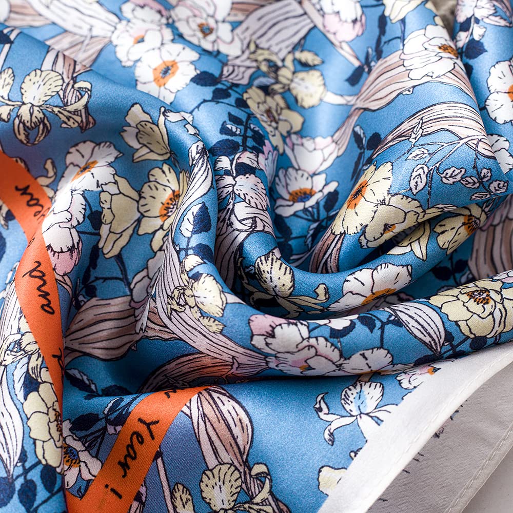 Close-up of blue silk in soft folds, white blooms beside the orange border band