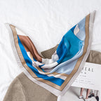 Blue mountain cat print draped over a camel knit sweater, the mountain cat face on top