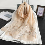 Khaki shawl styled on a chair beside a book and a framed print