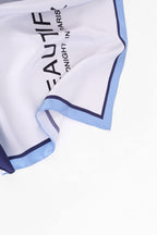 Flat view of the navy and sky blue colour block silk scarf with printed lettering