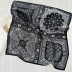 Black paisley square draped over white bedding, medallion centre and daisy edging