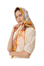Model wearing a tangerine rainforest print silk twill scarf tied as a headscarf