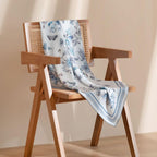 Pale blue butterfly and floral silk scarf draped over a wooden cane chair