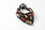 Cat print silk square rolled into a band and knotted, pale grey border along the corner